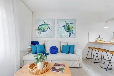 a living room with a white couch and blue pillows at Spacious Apt 2 Blocks to Beach and Collins Park in Miami Beach