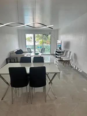 a living room with a dining table and chairs at Beatiful apartment 2nd Floor - SRT 3143 in Sunny Isles Beach