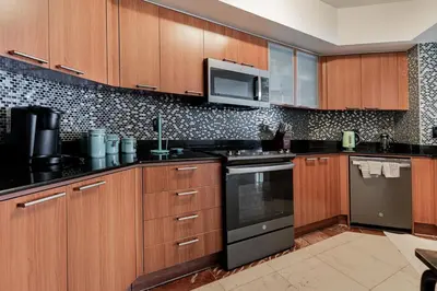 a kitchen with wooden cabinets and a stove top oven at Pierfront Escape in Sunny Isles Beach