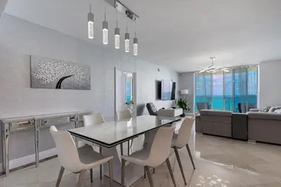 a dining room and living room with a table and chairs at Pierfront Escape in Sunny Isles Beach