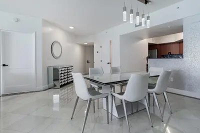 a dining room with a table and white chairs at Pierfront Escape in Sunny Isles Beach