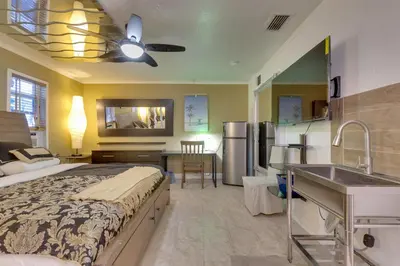 a bedroom with a bed and a kitchen with a sink at Fort Lauderdale Studio Near Beaches and Downtown in Fort Lauderdale