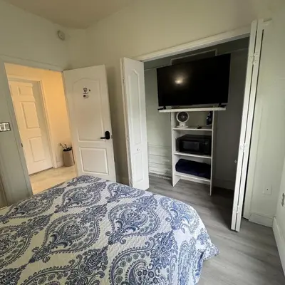 a bedroom with a bed and a flat screen tv at Room w Private Entrance near Airport, Dolphin Mall & FIU in Miami
