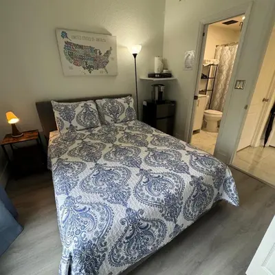 a bedroom with a bed with a blue and white comforter at Room w Private Entrance near Airport, Dolphin Mall & FIU in Miami