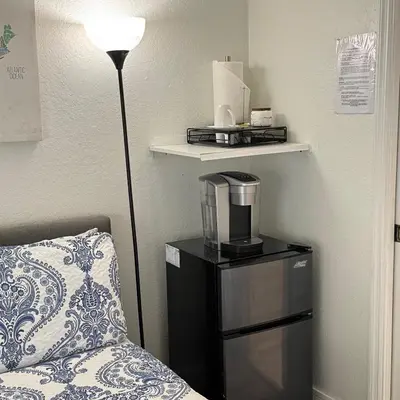 a hotel room with a coffee maker and a lamp at Room w Private Entrance near Airport, Dolphin Mall & FIU in Miami
