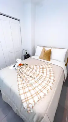 a white bed with a blanket on top of it at Comfortable 2BR Apartment with Pool and Gym, Steps from Jackson Memorial in Miami
