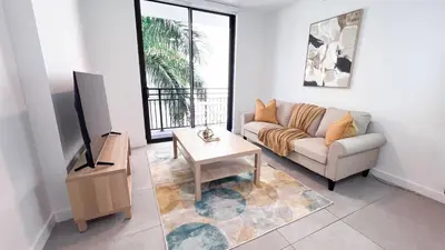 a living room with a couch and a tv at Comfortable 2BR Apartment with Pool and Gym, Steps from Jackson Memorial in Miami