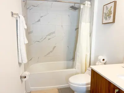 a bathroom with a white tub and a toilet at Comfortable 2BR Apartment with Pool and Gym, Steps from Jackson Memorial in Miami
