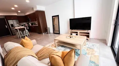 a living room with a white couch and a tv at Comfortable 2BR Apartment with Pool and Gym, Steps from Jackson Memorial in Miami