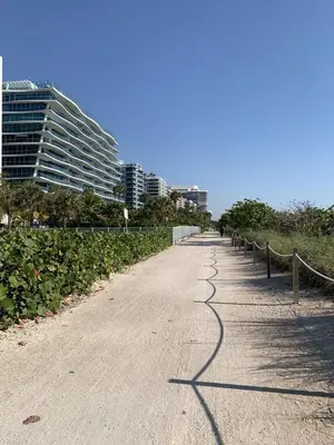 an empty road with a fence on the side at A place that will make you want to come back again in Miami Beach