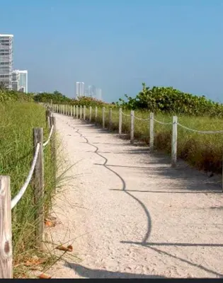 a dirt road with a fence on the side at A place that will make you want to come back again in Miami Beach