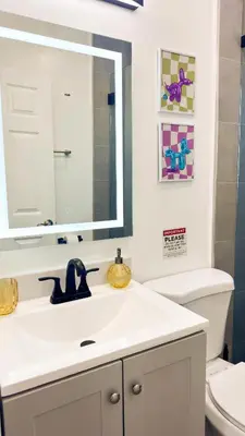 a white bathroom with a sink and a mirror at The Chill Pill - Wilton Drive and Jacuzzi in Fort Lauderdale