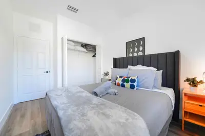 a bedroom with a large bed with a wooden headboard at Family-Friendly Townhouse w Private Parking Included in Miami
