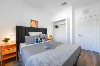 a white bedroom with a large bed and a door at Family-Friendly Townhouse w Private Parking Included in Miami