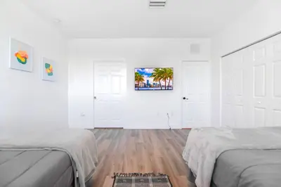 a white room with two beds and a painting on the wall at Family-Friendly Townhouse w Private Parking Included in Miami