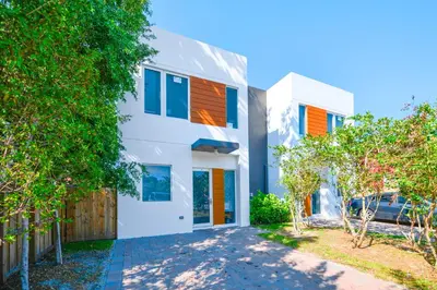 a white house with orange and blue windows at Family-Friendly Townhouse w Private Parking Included in Miami