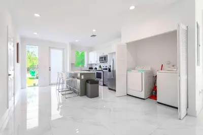 a kitchen with white appliances and a white floor at Family-Friendly Townhouse w Private Parking Included in Miami