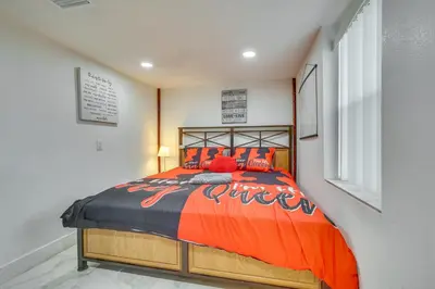 a bedroom with a bed with an orange comforter at 3 Mi to Beach Hollywood Studio with Yard! in Hollywood