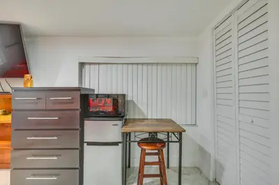 a small kitchen with a small table and a stool at 3 Mi to Beach Hollywood Studio with Yard! in Hollywood