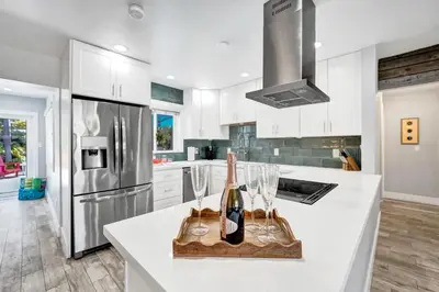 a kitchen with a counter with wine bottles and glasses at NEW! Private Oasis with Heated Pool Minutes to Wilton Dr and the Beach in Fort Lauderdale