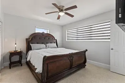 a bedroom with a bed with a ceiling fan at Family Oasis Near Hard Rock Stadium & Beaches in Norland
