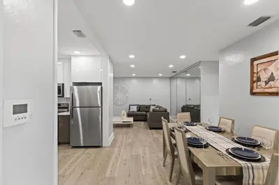a kitchen and living room with a table and a refrigerator at Family Oasis Near Hard Rock Stadium & Beaches in Norland