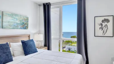 a bedroom with a bed and a large window at Tiffany Shoreline - PH Floor, Ocean View, Walk to beach in Fort Lauderdale