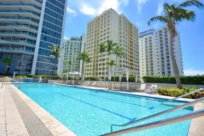a swimming pool with palm trees and buildings at ★Luxury Studio with king bed+Free Parking+Netflix★ in Miami