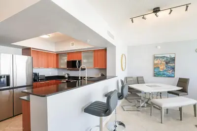 a kitchen with a table and chairs and a counter at A Breathtaking Oceanview - High Rise Luxury Condo in Sunny Isles Beach