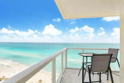 a balcony with a table and chairs and the ocean at Balcony on the Ocean - Picture Perfect in Sunny Isles Beach
