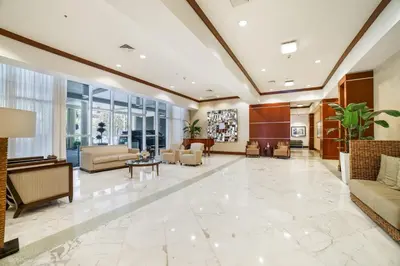 a lobby with couches and tables and windows at Balcony on the Ocean - Picture Perfect in Sunny Isles Beach