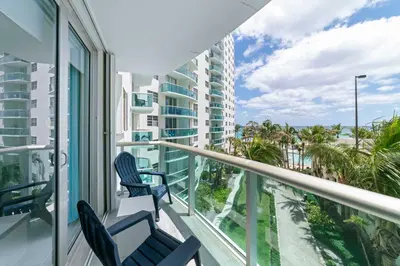 a balcony with chairs and a view of the ocean at Ocean Wind - Luxury Beachfront Condo with Pool & Gym in Hollywood