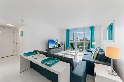 a living room with a couch and a table at Ocean Wind - Luxury Beachfront Condo with Pool & Gym in Hollywood