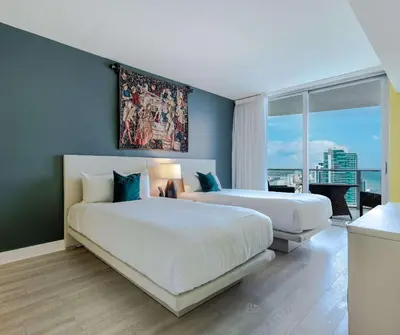 two beds in a bedroom with blue walls at Luxury Living on the Beach with Resort Amenities in Hollywood