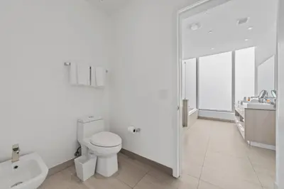 a white bathroom with a toilet and a sink at 2BR Ocean Penthouse - Private Terrace & Hot Tub in Hollywood
