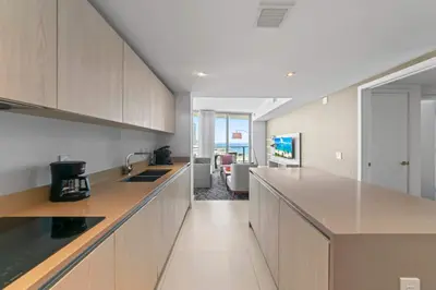 a kitchen with wooden cabinets and a counter top at Sunny Balcony - Beautiful Stay for 2 with Ocean Views & Resort Amenities in Hollywood