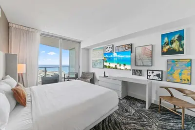 a bedroom with a bed and a desk and a window at Sunny Balcony - Beautiful Stay for 2 with Ocean Views & Resort Amenities in Hollywood