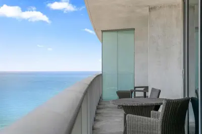 a balcony of a building with chairs and the ocean at Sunny Balcony - Beautiful Stay for 2 with Ocean Views & Resort Amenities in Hollywood