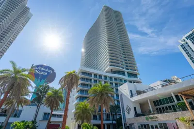 a tall building with palm trees in front of it at Sunny Balcony - Beautiful Stay for 2 with Ocean Views & Resort Amenities in Hollywood
