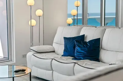 a white couch with blue pillows in a living room at Oasis on the Beach - For 4 in Miami Beach