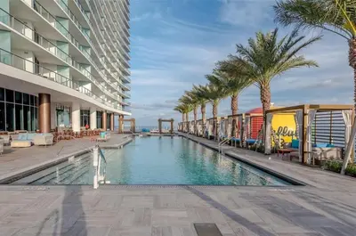 a swimming pool in the middle of a building with palm trees at Cosy 1 Bedroom Breathtaking Ocean Views at LYFE Resort in Hollywood
