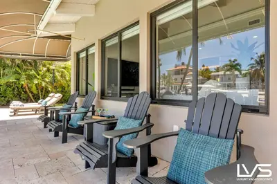 a row of chairs sitting on a patio at Villa Marea - Heated Pool Spa & Water Views in Fort Lauderdale