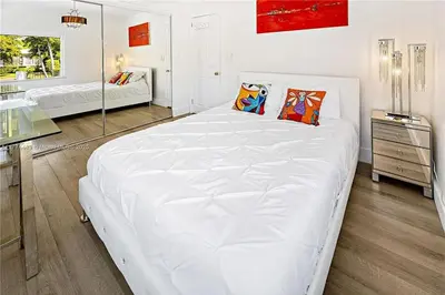 a large white bed in a room with a mirror at Bayside Bliss on Marseille in Miami Beach