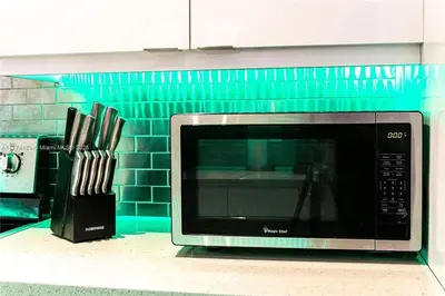 a microwave sitting on a kitchen counter with knives at Bayside Bliss on Marseille in Miami Beach