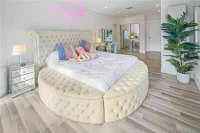 a large white bed with a person laying on it at Bayside Bliss on Marseille in Miami Beach