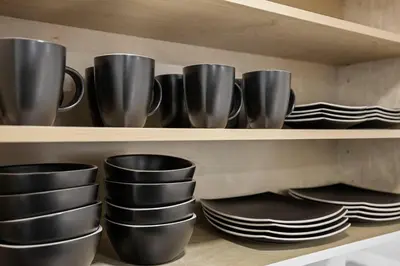 a row of black cups and plates on a shelf at Walk To Coral Gables | SLEEP 8| Free BEACH Package in Miami