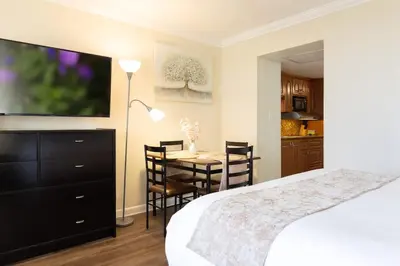 a bedroom with a bed and a table with chairs at Beachfront Studio - Marco Polo Sunny Isles -2Beds in Sunny Isles Beach