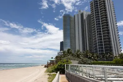 a beach with tall buildings and the ocean at Beachfront Studio - Marco Polo Sunny Isles -2Beds in Sunny Isles Beach