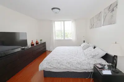 a white bedroom with a bed and a television at Apartment 2 Bedrooms at Yacht Club of Aventura in Miami