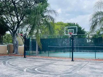 a basketball hoop on a tennis court with a palm tree at Apartment 2 Bedrooms at Yacht Club of Aventura in Miami